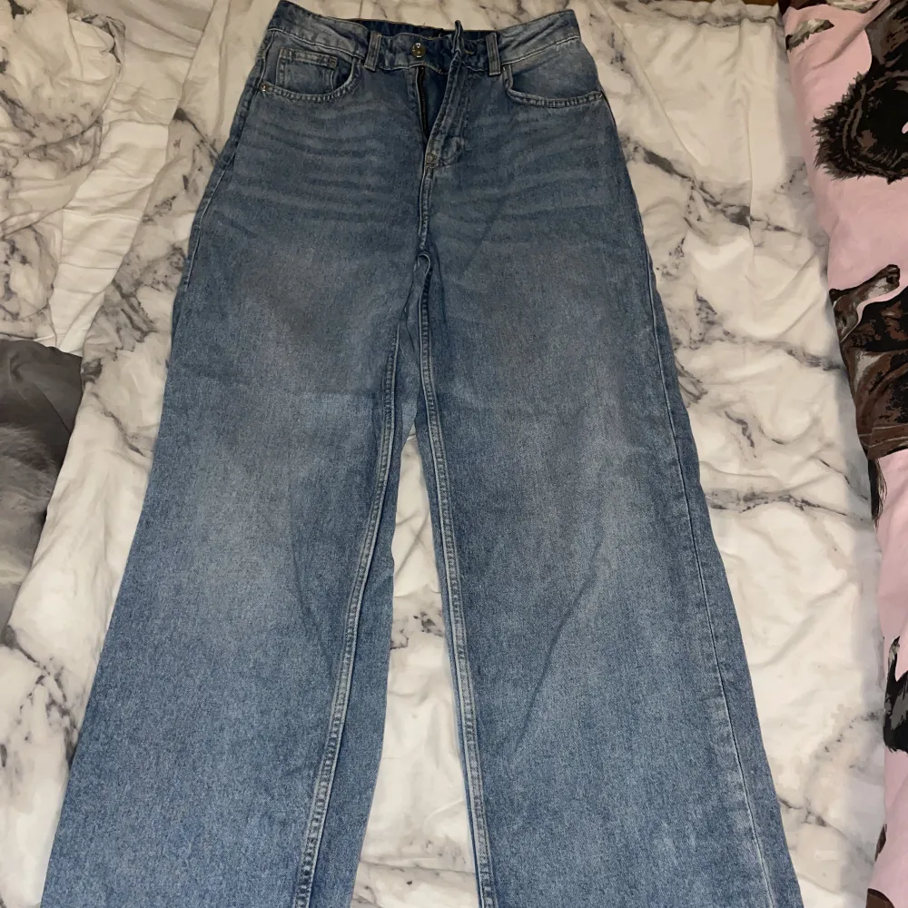 Blå jeans från H&M, mycket sparsamt använda och i bra skick!  De är i storlek 34 men passar bra på mig som vanligtvis har 36. Tveka inte att höra av er om frågor! Kontakta mig innan ni använder köp nu🥰. Jeans & Byxor.