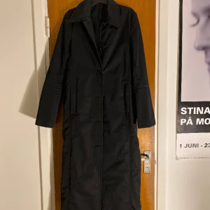 Fin lång svart kappa - Lång svart kappa från & other stories, säljes pga för liten för mig. Skulle säga att den passar en S. Finns ett bälte till som inte syns på bilden men som följer med