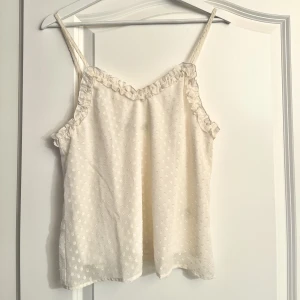 Vitt linne med volanger - Oanvänt jättegulligt linne med volanger från bik bok, säljer p.g.a för litet, storlek xs