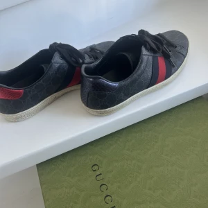 Gucci skor - Ett par svarta Gucci ”Ace” skor inköpta på Guccis hemsida 2022. Storlek 41.5 men är stora i storleken och passar även 42/42,5. Använda under en ettårsperiod med viss tecken på användning på insidan. Kvitto finns.