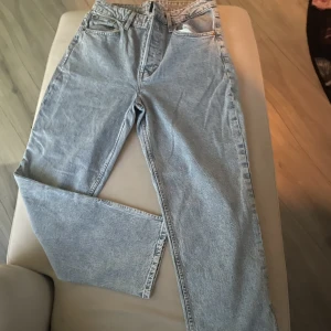 Jeans - Ljusblåa höjmidjade byxor, breda ben och använda 1 gång. Tror dessa klassas som momjeans 