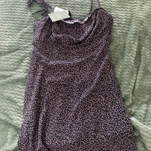 Klänning - Klänning med blommönster som aldrig kommit till användning, lappen finns fortfarande kvar.