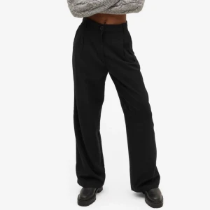 kostymbyxor - Super fina kostymbyxor från Monki med hög midja. Köpte själv ett par exakt likadana när jag inte längre kunde ha dessa i storlek ☺️är själv 163 och dem är långa men lägger sig fint över skon 🖤