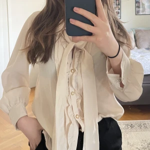 Blus - Säljer min beigea blus som passae både till jobb och middagar ute. Saknar tyvärr både den översta och understa knappen. Här är måtten: Hals till botten - 34 cm Bredd - 50 cm Armlängd - 54 cm