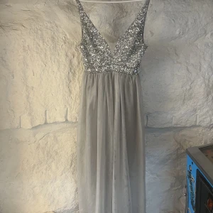 Balklänning från Bubbleroom - Balklänning köpt från Bubbleroom (nypris 1100 kr) , använd en gång till min bal och säljs nu för att den bara legat hemma oanvänd. V-ringad med strass på överdelen & sidenkjol med meshtyg ovanpå på underdelen. 