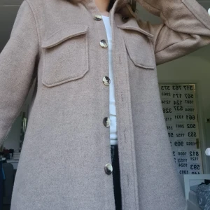 Kappa - En brun kappa med brun och beiga knappar