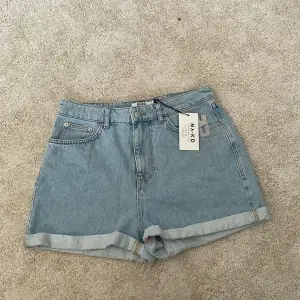 Helt!!! Oanvända jeans shorts från NA-KD. Rätt så höga i midjan och uppvikta i benet. Dom heter: Fold  Up Mom Shorts. ( porto tillkommer) 