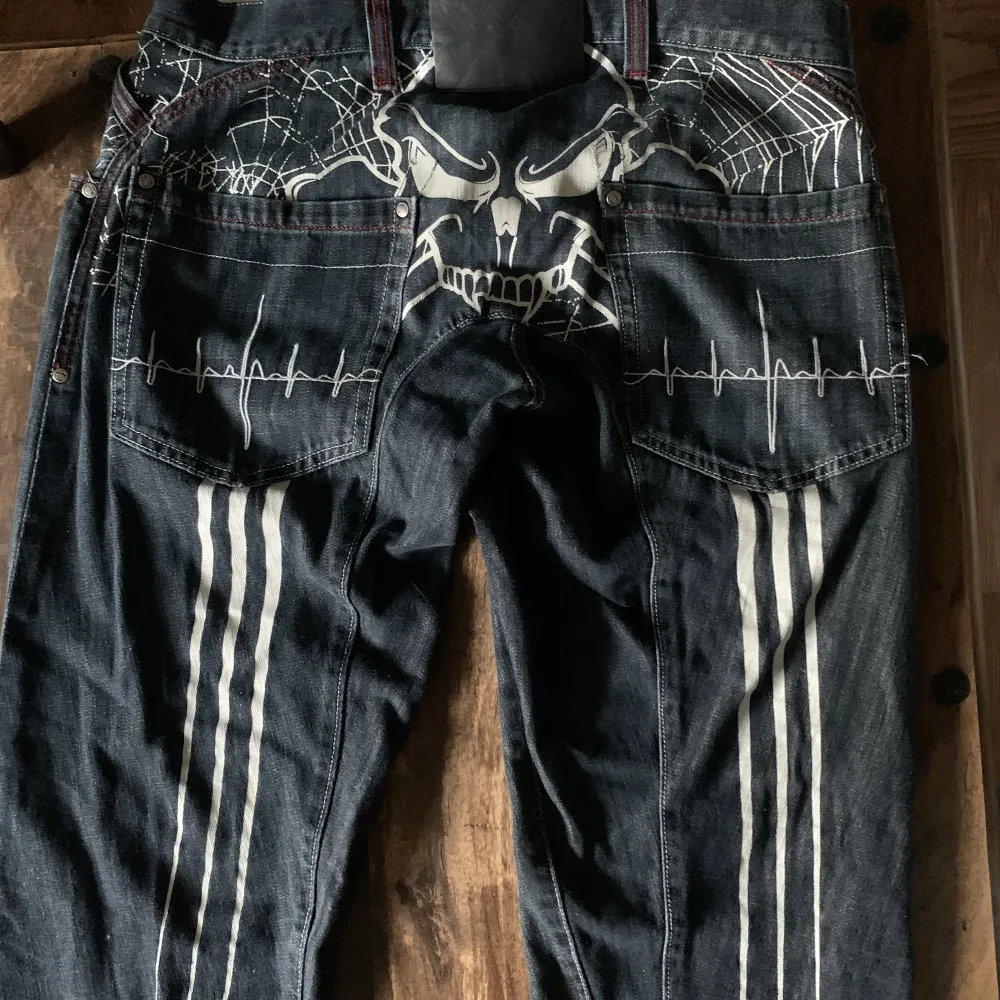 Tvär feta wax action jeans med en dödskalle på baksidan och röd stitching runt om. Bra skick och sällsynta.. Jeans & Byxor.