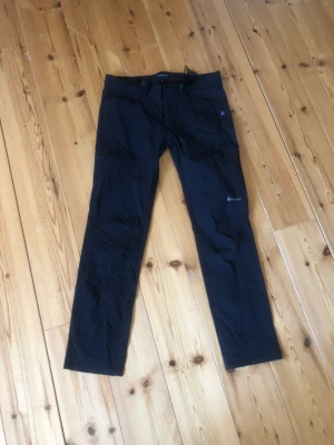 Svarta cargobyxor  - L byxor med kedja och spänne. Funkar bäst på raka och inte kurviga kroppar.