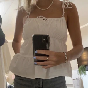 Blus med knytband  - Säljer denna somriga topp från hm då den tyvärr inte kommit till användning. Första bilden är lånad men resten tagna själv. Toppen har inga defekter och har används fåtal gånger. Är i stl 38 men går att sjustera i banden.