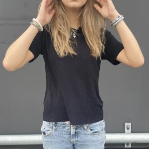 Svart t-shirt - Svart t-shirt. Skönt material att ha på sig, tyngre än en vanlig t-shirt. Vet inte vad det är för material men det är väldigt fint stickad.