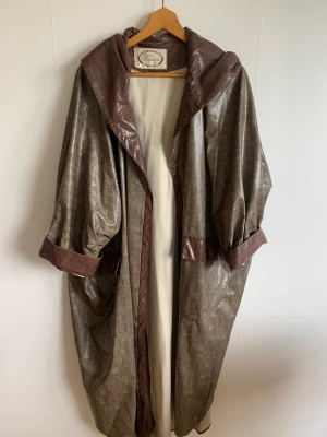 Amazing regnkappa  - Otroligt fin regnkappa i snake mönster. Oversized och med luva. Vintage och väldigt originell 