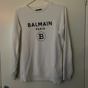 Balmain Tröja  - Säljer min vita Balmain tröja. Den är köpt på Farfetch. Str 14y/xs. Cond: 9/10 Ny pris: 3800kr Mitt pris: 500
