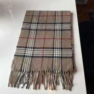 Burberry halsduk  - Hej ! Jag säljer nu denna riktigt feta burberry halsduken. det är en lite gammlare Model men riktigt bra skick 9/10 i skick. Perfekt nu till vintern, lägg gjärna ett bud vid intresse det finns inga burberry logor på den för det är en lite gammlare model. 
