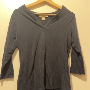 Michael kors - gulddetaljer  - Enkel långärmad tröja med gulddetaljer där det står michael kors 