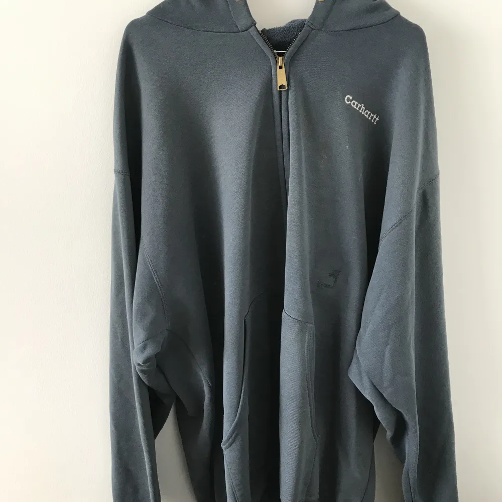 Säljer en Carhartt hoodie i grå, strl XXL. Oversized, har en liten reva på magen men gör den bara snyggare enligt mig.. Hoodies.