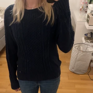 Mörkblå stickad tröja - En fin mörkblå kabelstickad tröja från Lindex i bra och tåligt material.  Tröjan är i storlek M men passar personer som har S också.