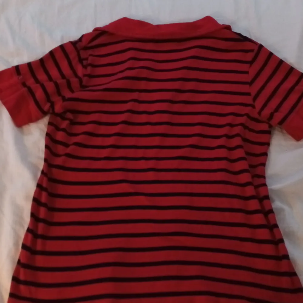 En snygg röd, svart randig tröja med krage och en liten ficka på bröstet med text (3:e bilden). T-shirts.