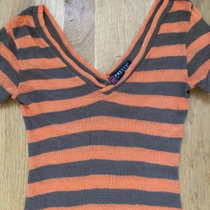 Y2k stickad T-shirt - Passar som S, orange och brun randig. Från pretty girls. Armhåla till armhåla 39 cm, längd 75 cm.