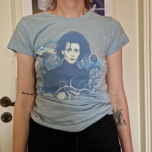 Edward Scissorhands tröja - Blå tshirt i dammodell med Edward Scissorhands-tryck. Står att den är strl L på lappen, men skulle säga att den är mer som S/M.
