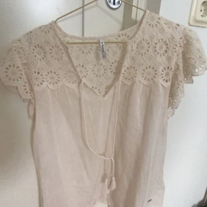 Blus - Fin vit blus som är lite broderad där uppe både fram och bak. Har ett snöre man kan knyta om man vill. Skriv för fler bilder!