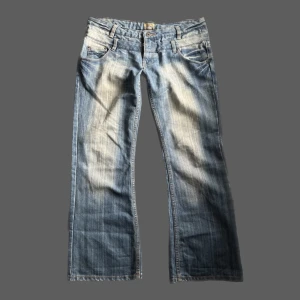 Lågmidjade Y2K bootcut jeans - Super snygga lågmidjade y2k bootcut jeans som sitter rätt baggy! midjemåttet: 47cm tvärsöver innerbenslängd: 76cm PS. KOLLA IGENOM MITT KONTO NI KOMMER HITTA MÅNGA Y2K OCH VINTAGE PLAGG 