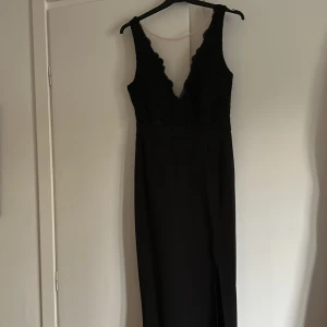 Långklänning/balklänning - Säljer denna klänning som jag endast använt 1 gång. Spets upptill och relativt tjockt tyg vilket ger ett lyxigt intryck. Dragkedja där bak för att stänga klänningen. Slits vid vänster ben. Jag är 164cm och då nuddar den marken lite.