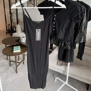 Kort svart klänning från Boohoo med spagetti straps. Aldrig använd, prislapp kvar! Ej steamad på bilden så säg till om du vill ha bättre bilder 🩷