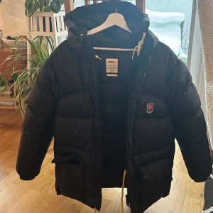Fjällräven jacka  - Fjällrävens klassiska Expedition Down Jacket i stl XXS i färgen svart. Är unisexjacka så passar alla. Storleken är mer som en x-small eller small för dam. det är inte  lite- modellen. Mycket varm och fin jacka som är köpt på Naturkokompaniet. Nypris  7000