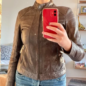 Läderjacka Street One - Brun/grå läderjacka från Street One. Bra skick och inga tecken på slitage. Blommigt foder. Storlek 38 men passar bra på mig som är strl 40