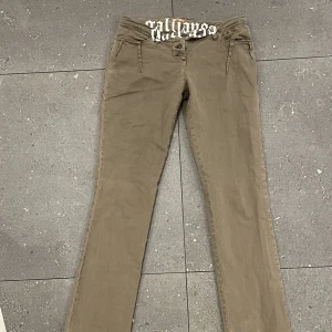 Lågmidjade jeans - Skit snygga lågmidjade gröna jeans med cool text fram och vit detalj på bak.