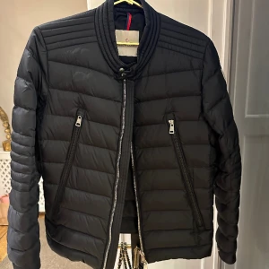 Moncler dunjacka - Moncler dunjacka i biker modell med låg krage. Fint skick. Lite använd. 