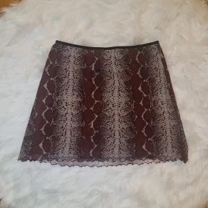 Kjol - Kjol från urban outfitters i lila ormmönster. Oklart vilken storlek det är men skulle gissa på S/M. Stretchigt matereial