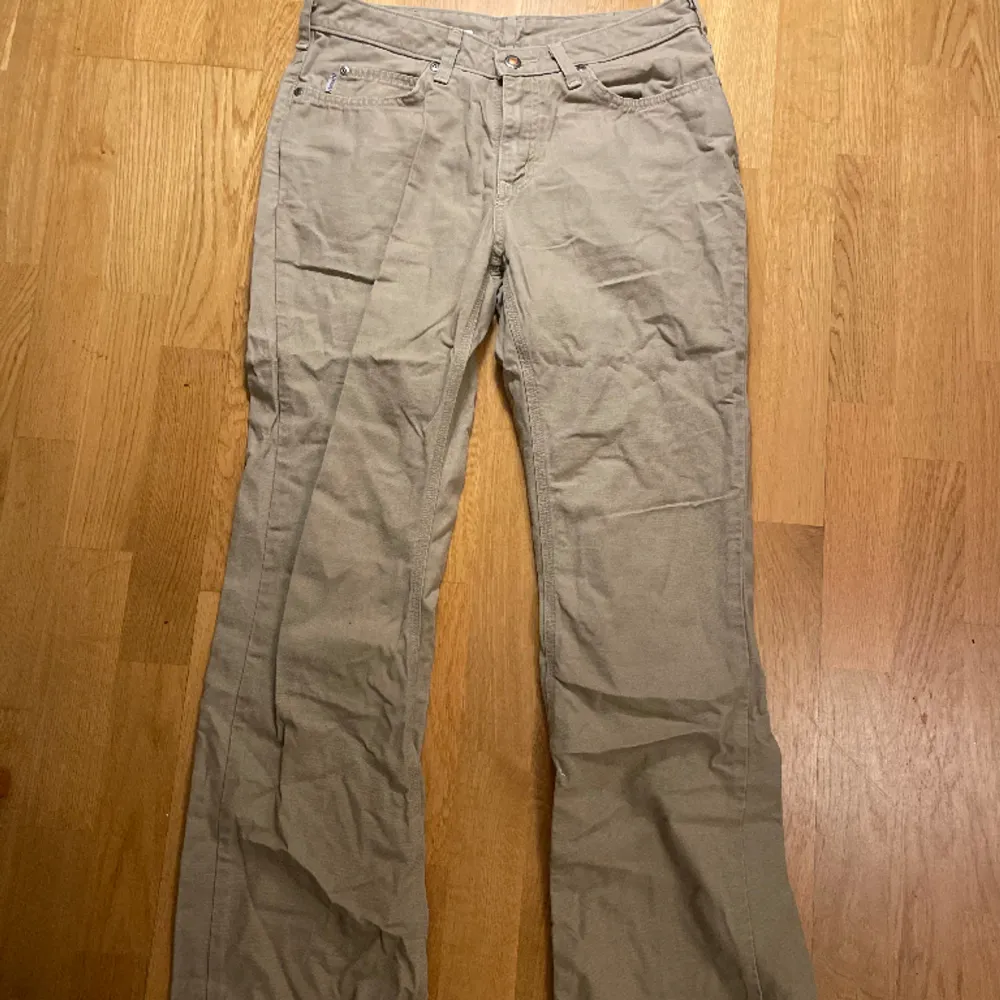 Beiga bootcut lågmidjade Carhartt jeans. Aldrig sett modellen förrut. De e i jätte fint skick bara en strykning behövs :) jag e 165 cm. MÅTT: 38cm midja mätt tvärs över 80cm innerbenslängd . Jeans & Byxor.