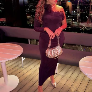 Ruffle maxi dress - One shoulder-klänning med voluminös volang upptill. Klänningen är svart och har figurnära passform. Den har lång ärm, rynkningar i sidosömmen, slits bak, stretchig kvalitet och en midilängd.