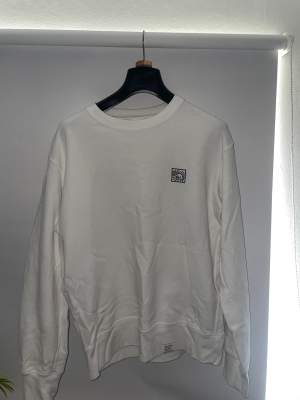 En vit design sweatshirt från Uniqlo. Designad av Keith Haring