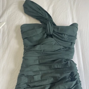 Mörkgrön Zara Klänning  - Mörkgrön Zara klänning med en öppning på sidan och fram, tajt och slutar ungefär vid halva låret på mig. Andvänt 2 gånger men ser helt ny ut💕Köpt för 499kr