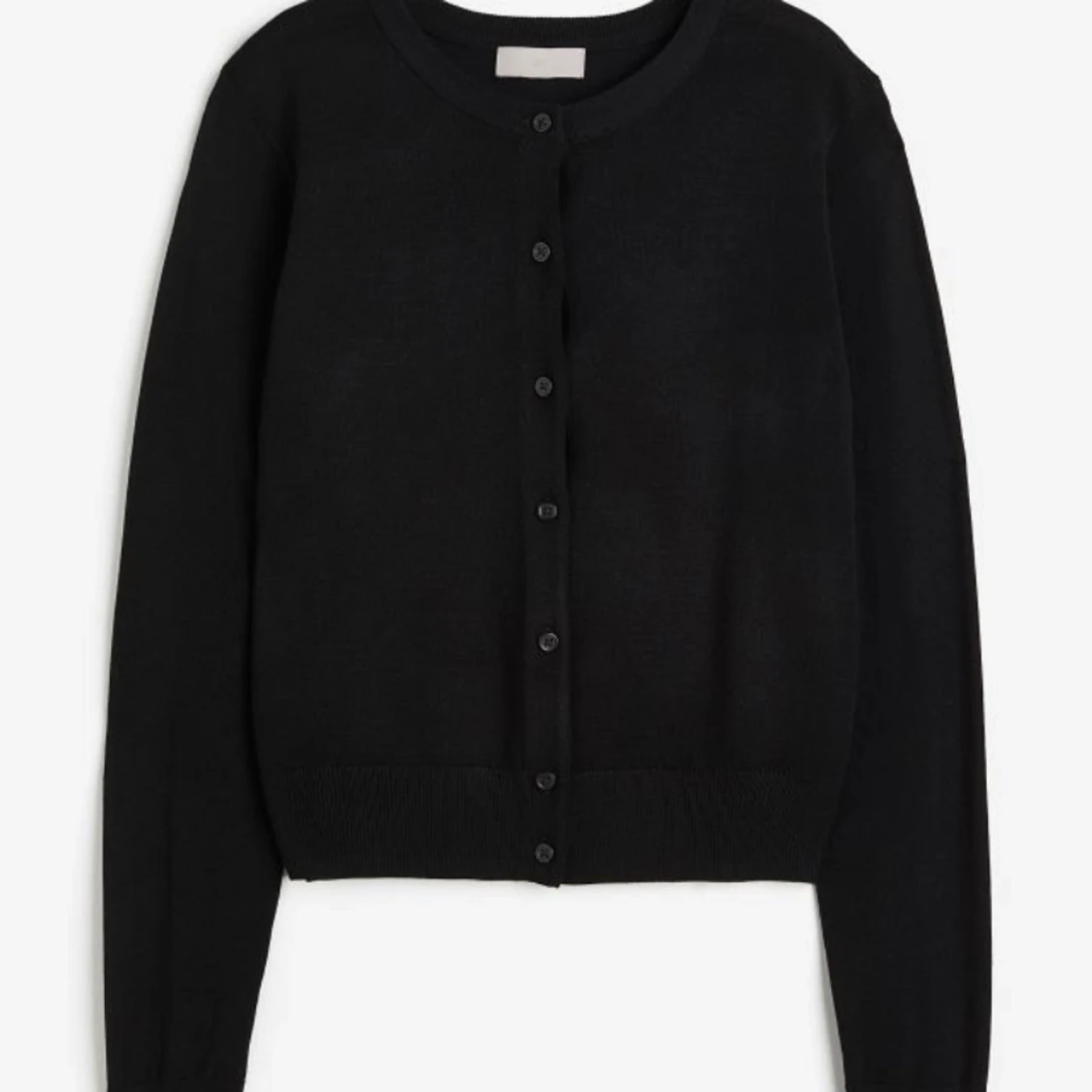 knappkofta med svart knappar