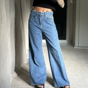 Blå vida jeans från Na-kd - Blå vida jeans från na-kd. Använda 1 gång. Avklippta längst ned då de var superlånga i benen. Jag är 160cm lång