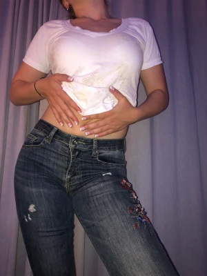 Mörkblå jeans med dekoration  - Mörkblå straight leg jeans med blomdekoration. Bra kvalite och bra skick! Pris kan diskuteras 