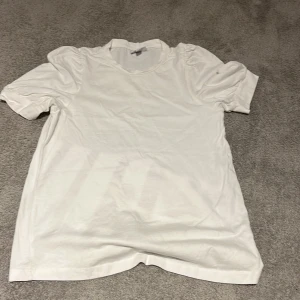 Vit t-shirt med puffiga axlar - Denna fina tröja kommer aldrig till användning, synd för den är super fin 🙁