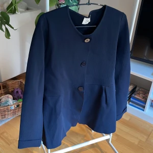 Användbar kavaj/kofta - Stilren och din kavaj/kofta i stadigt men ändå mjukt material, lätt A-formad. Viskos och nylon.  Som ny. 