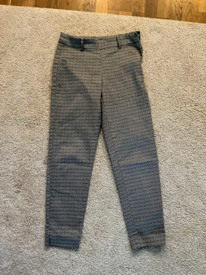 Kostymbyxa - Super fina kostymbyxor, dom är blå vita med mönster. Sitter super bra i rumpan och det finns även en liten slits längst ner på båda byxbenen. Dom är lite kortare så dom slutar en nedanför knäna. Från H&M i storlek 34 men passar även 36 & 38 då jag har 38🫶🏼