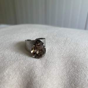 Superfin ring från Caroline svedbom, väldigt ny och fortfarande superfin. Beige/brun färg på kristallen. 