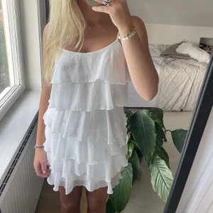 Sommarklänning  - En vit volangklänning som passar till allt💗 Jag är 172 cm och den sluter ovanför mitten av låret, den sitter dock åt så den åker inte upp!