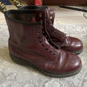 Vinröda Doc Martens  - Super fina röda doc martens som inte kommer till användning längre. De är lite slitna men inte överdrivet och har inga hål, fungerar utmärkt. Har dock inga skosnören storlek 39. 