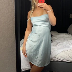 Satin klänning - En skit snygg stainklänning, den är ljusblå med öppen rygg. Knappt använd, köparen står för frakt!
