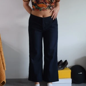 Marinblå byxor  - Marinblå kostymbyxor  Strl: 40  Mått: midja 81cm, benlängd 66,5cm, benöppning 28cm Material: 64% polyester 34% viskos 2% elastan Märke Esmara Skick: använt skick, finns tecken på användning som exempelvis nopprigt tyg 