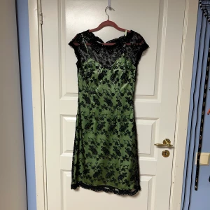 Festklänning - Festklänning med insydd grön underklänning. Insydda paddar vid brösten. Storlek 36. Kommer ner till knäna på mig som är ca 170. Använd en gång. 