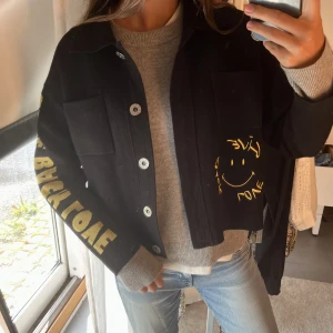 Sandro x Smiley jacka - Asball jacka från Sandro x Smiley kollektionen! Den är i tyg/stickat material och går att använda både som jacka och kofta (perfekt nu till sensommaren!)😍Den har tryck med ”give back love” både fram, bak och på ärmen. Nypris ca 3000. 